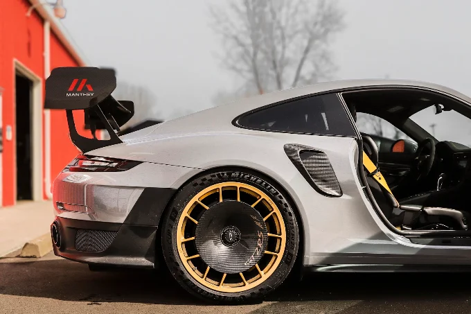 Rear side view of a grey Porsche 911 GT2 RS with its door open