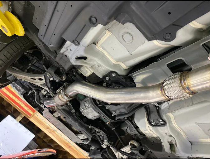 Stainless exhaust pipework fitted on the underside of a Porsche