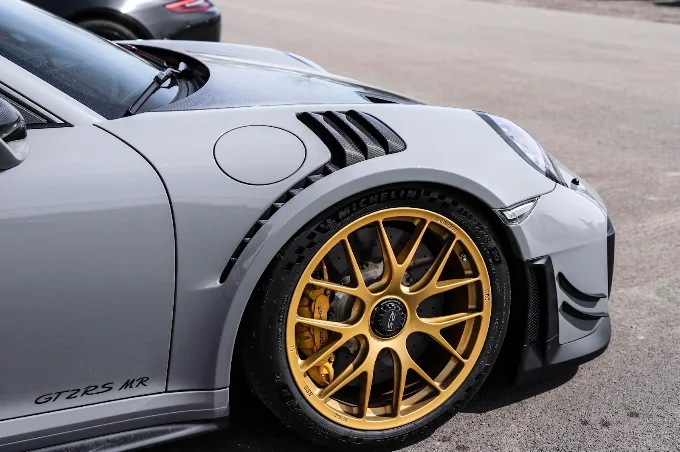Gold front wheel and vented fender on a grey Porsche 911 GT2 RS