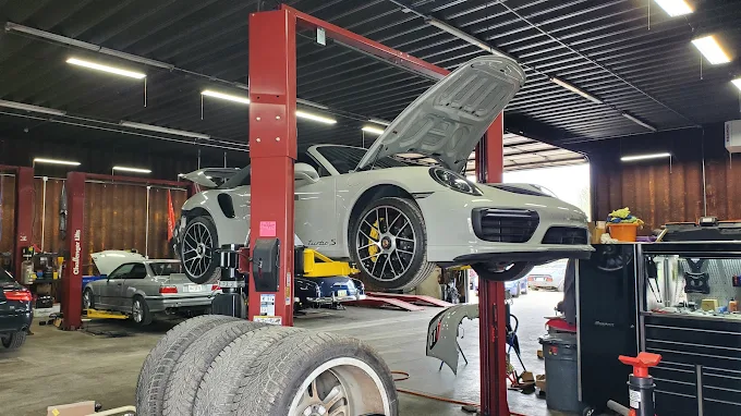Silver Porsche 911 Turbo raised on a lift with its hood open