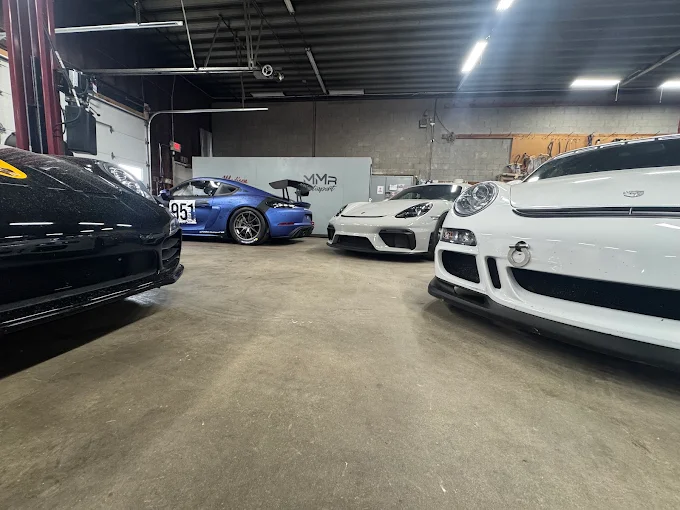 Porsches parked side by side on the MMr Autosport shop floor