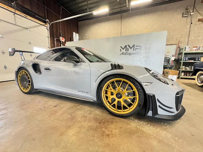 Grey Porsche 911 GT2 RS with gold wheels inside MMr Autosport